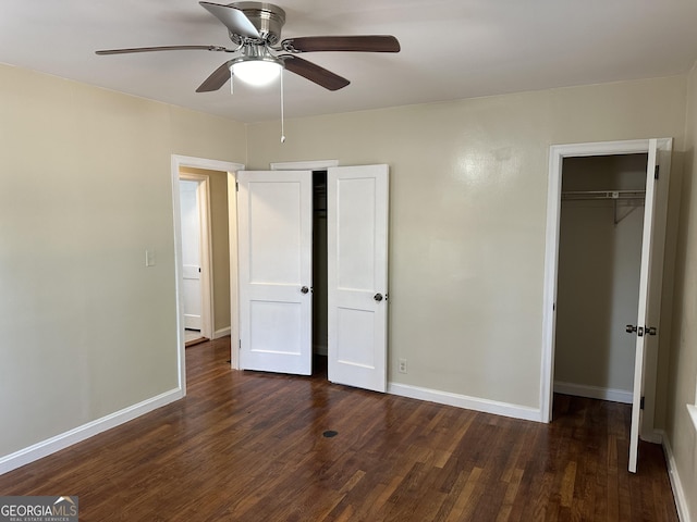 unfurnished bedroom with a closet, ceiling fan, dark wood-type flooring, and baseboards