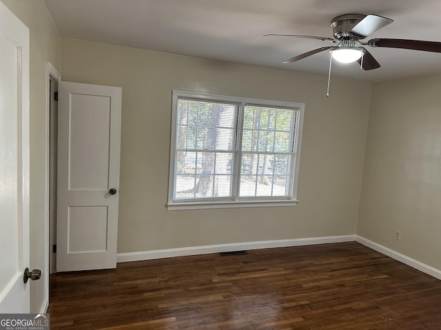 empty room featuring dark wood finished floors, ceiling fan, and baseboards