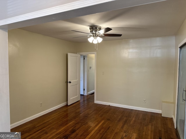 spare room with baseboards, dark wood-style flooring, and ceiling fan