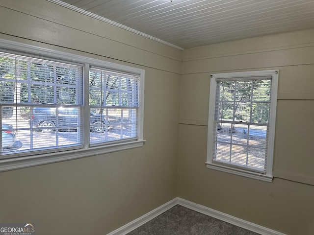 empty room with dark carpet and baseboards