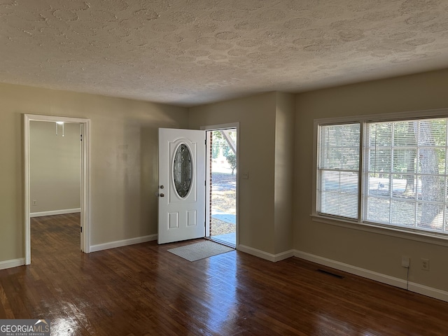 entrance foyer featuring dark wood-style floors, baseboards, and a textured ceiling