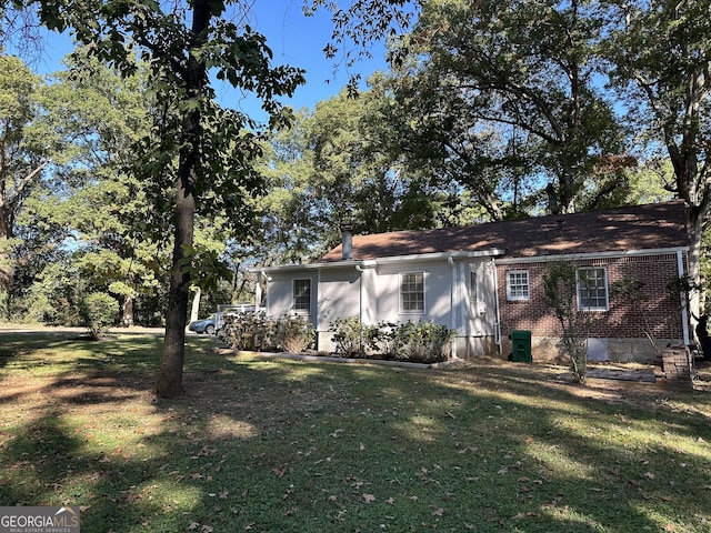 view of front of property featuring brick siding and a front lawn