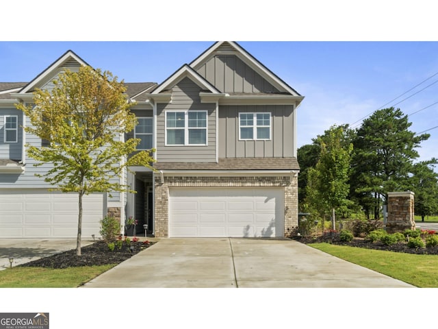 view of front of house with brick siding, board and batten siding, concrete driveway, and an attached garage