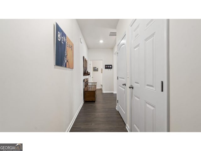 hallway featuring dark wood-type flooring, recessed lighting, baseboards, and visible vents