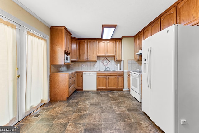 kitchen with white appliances, visible vents, a sink, light countertops, and backsplash