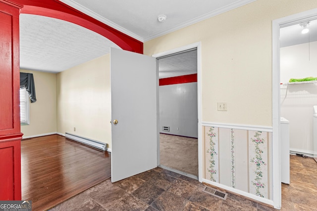 unfurnished room with visible vents, crown molding, baseboard heating, stone finish floor, and a textured ceiling