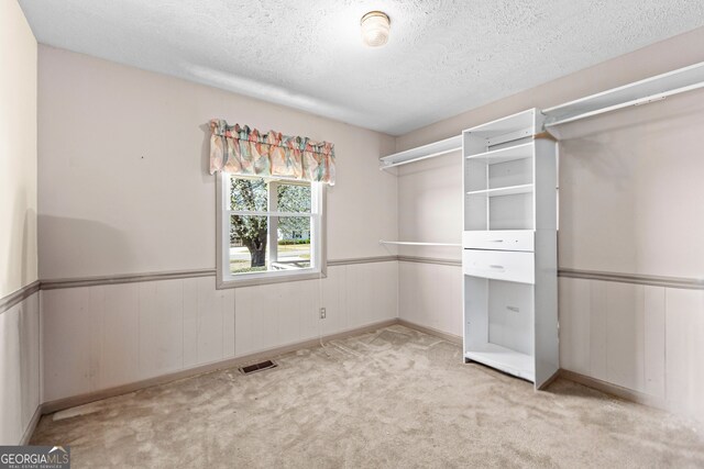 walk in closet with light colored carpet and visible vents