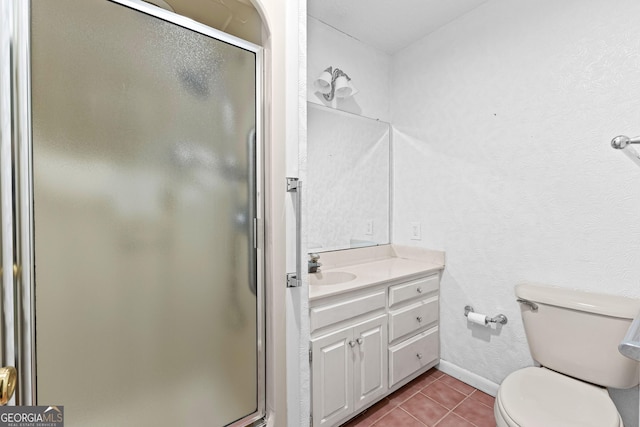 bathroom with toilet, a shower stall, tile patterned flooring, baseboards, and vanity