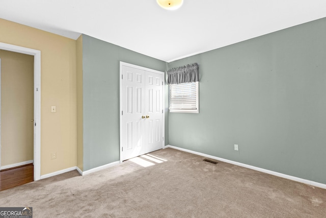 unfurnished bedroom featuring carpet, a closet, and baseboards