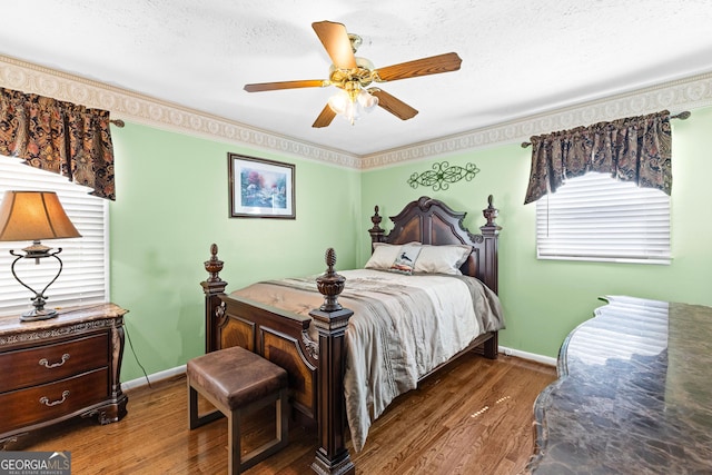 bedroom with baseboards, a textured ceiling, and wood finished floors