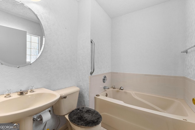 full bath with a sink, wallpapered walls, a garden tub, and toilet