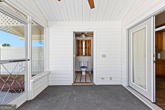 unfurnished sunroom with wooden ceiling and a ceiling fan