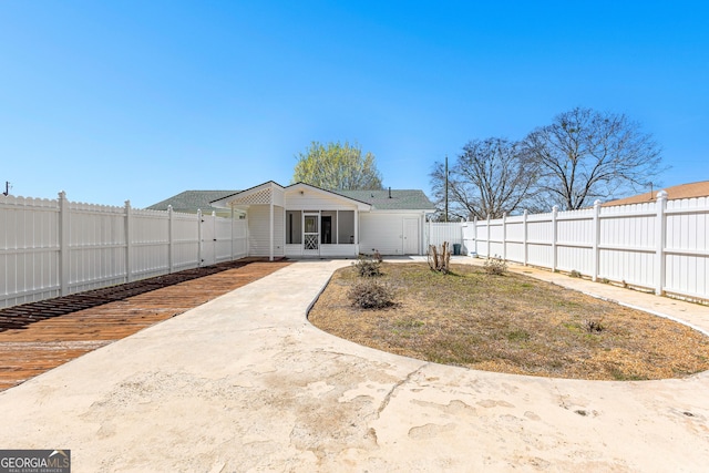 back of house with a fenced backyard