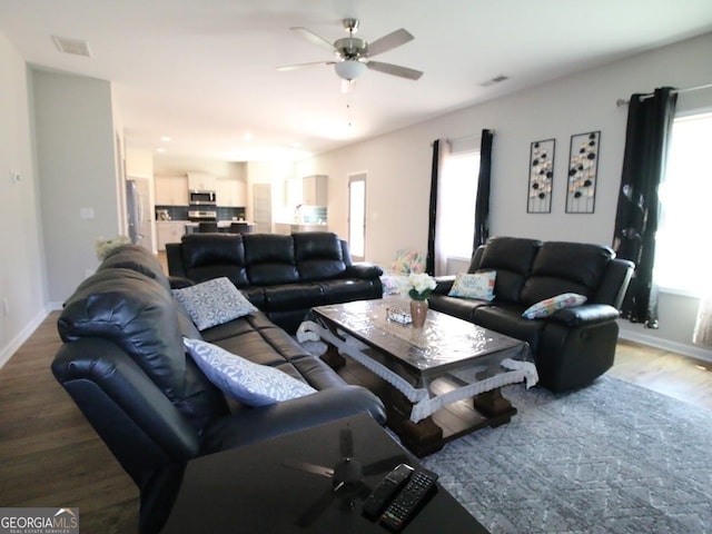 living area with a wealth of natural light, visible vents, and light wood-type flooring