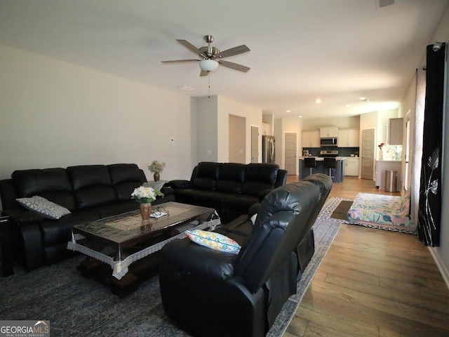 living area with recessed lighting, a ceiling fan, and light wood-type flooring