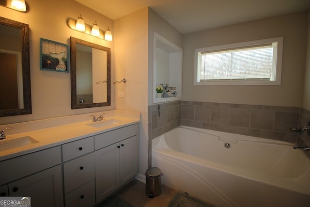 full bathroom featuring a sink, a garden tub, and double vanity