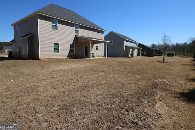 rear view of house featuring a yard