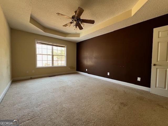 dining room with wood finished floors, a wainscoted wall, a tray ceiling, a textured ceiling, and a notable chandelier