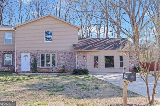 view of front facade featuring brick siding and a front lawn