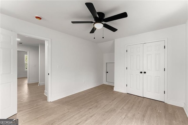 unfurnished bedroom featuring light wood-style flooring, baseboards, and a closet