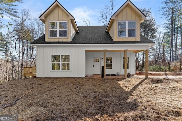 back of house featuring a porch, board and batten siding, and roof with shingles