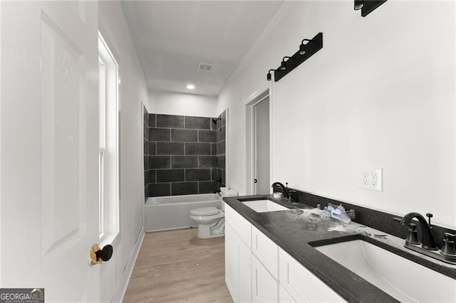 full bathroom with a sink, visible vents, toilet, and wood finished floors