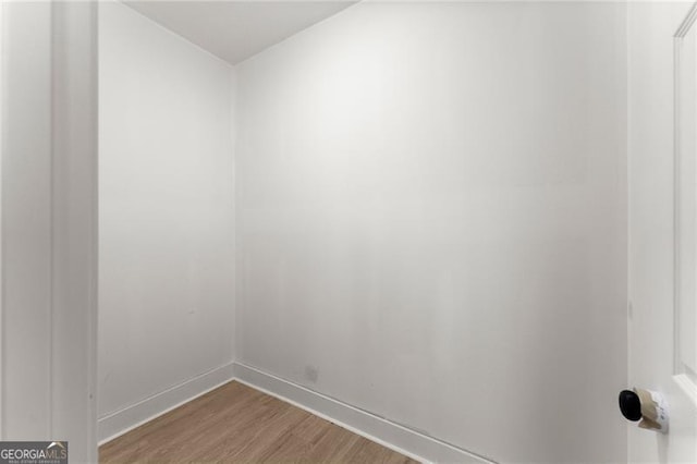 empty room with baseboards and wood finished floors