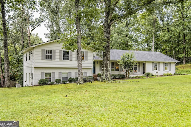 split level home featuring brick siding and a front yard