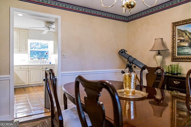 dining room with light tile patterned floors and ceiling fan with notable chandelier