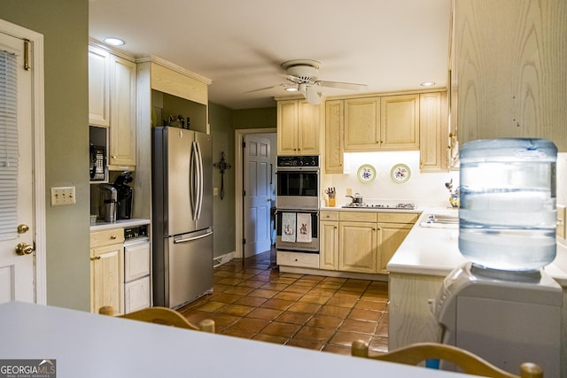 kitchen featuring dark tile patterned flooring, light brown cabinetry, stainless steel appliances, light countertops, and ceiling fan