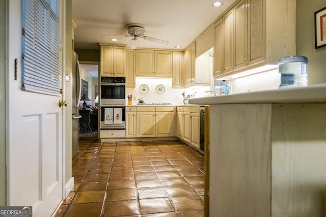 kitchen featuring a ceiling fan, light brown cabinets, stainless steel dishwasher, double oven, and light countertops