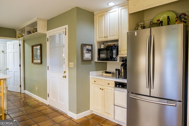 kitchen featuring baseboards, dark tile patterned flooring, freestanding refrigerator, light countertops, and black microwave