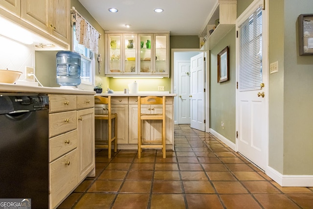 kitchen with recessed lighting, light countertops, glass insert cabinets, baseboards, and dishwasher