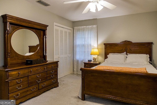 bedroom with ceiling fan, visible vents, a closet, and light carpet