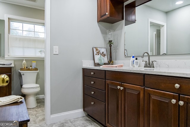 bathroom featuring vanity, toilet, and baseboards