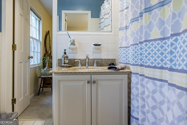 bathroom with tile patterned floors, backsplash, vanity, and tile walls