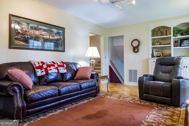 living area with visible vents, rail lighting, and stairs