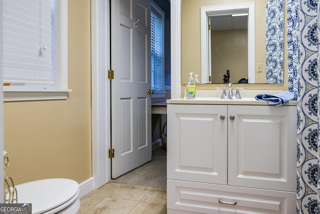 bathroom featuring tile patterned flooring, toilet, vanity, and baseboards