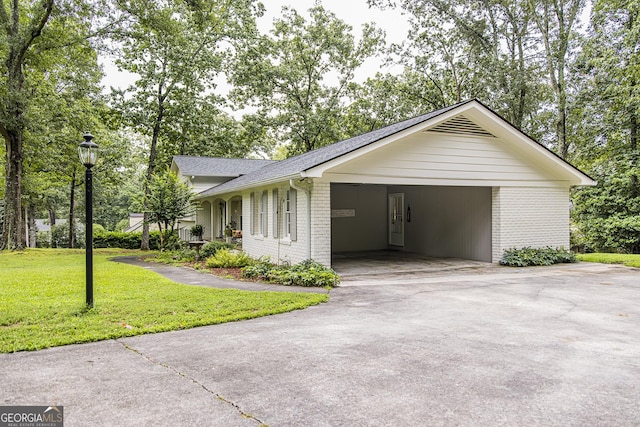 view of side of property with driveway, roof with shingles, a yard, a carport, and brick siding