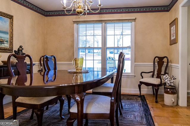 dining space featuring baseboards and an inviting chandelier