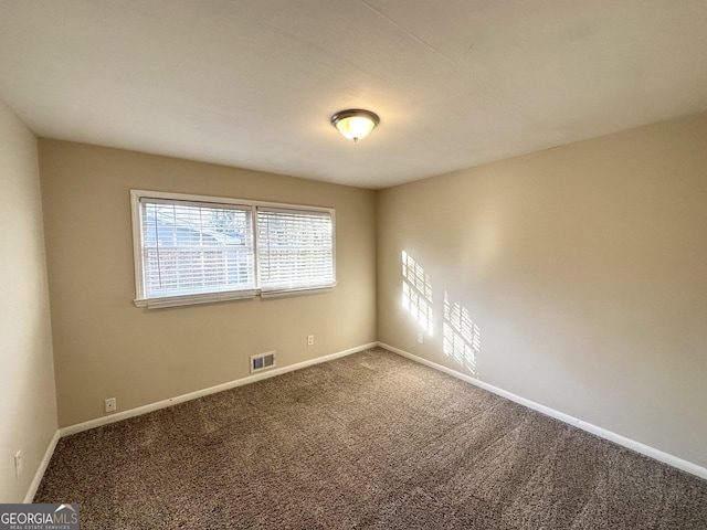 carpeted spare room featuring baseboards and visible vents