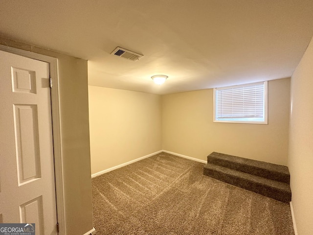 basement with stairway, baseboards, visible vents, and carpet floors