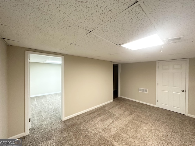 finished basement with a drop ceiling, visible vents, baseboards, and carpet