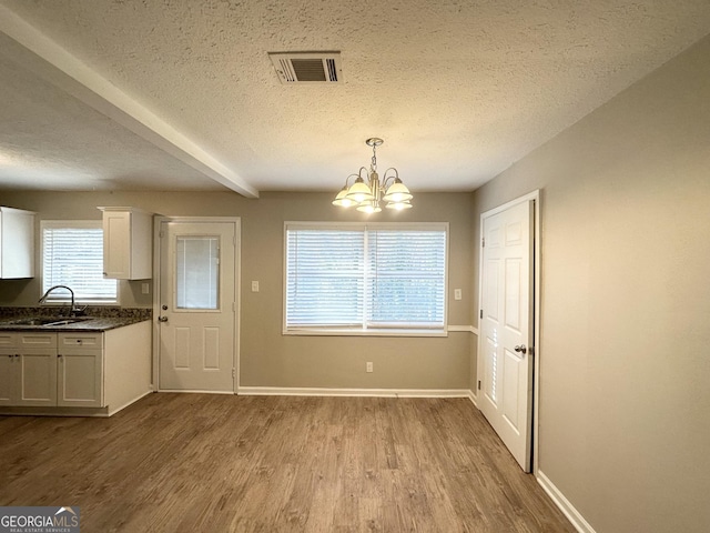 3395 Longleaf Dr, Decatur, GA 30032 - unfurnished dining area with a textured ceiling, wood finished floors, visible vents, and a sink