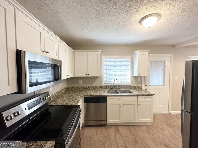 3395 Longleaf Dr, Decatur, GA 30032 - kitchen featuring a sink, white cabinets, appliances with stainless steel finishes, a textured ceiling, and light wood-type flooring