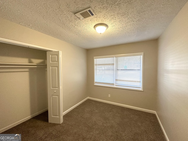 3395 Longleaf Dr, Decatur, GA 30032 - unfurnished bedroom with baseboards, visible vents, a closet, a textured ceiling, and dark colored carpet