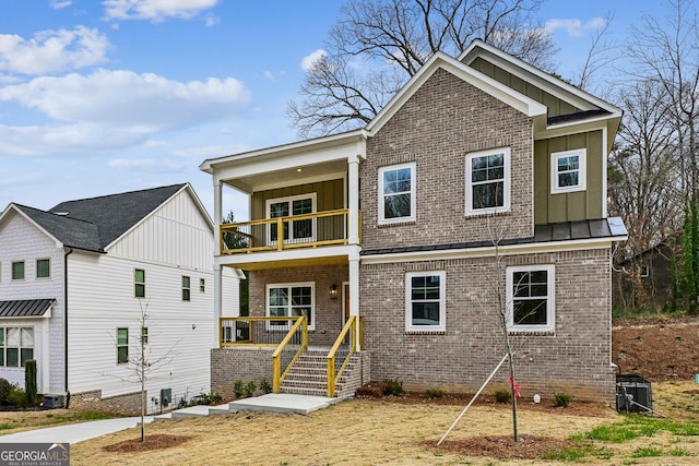 view of front of property featuring brick siding, board and batten siding, and a balcony