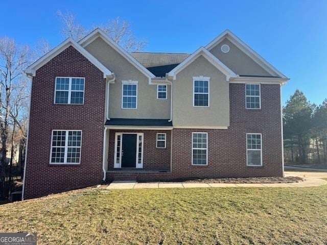 view of front of house with brick siding, stucco siding, and a front lawn