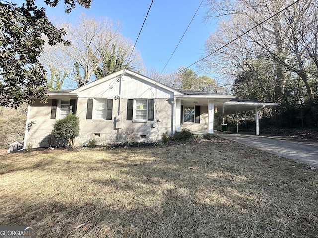 view of front of property featuring brick siding, an attached carport, concrete driveway, a front yard, and crawl space