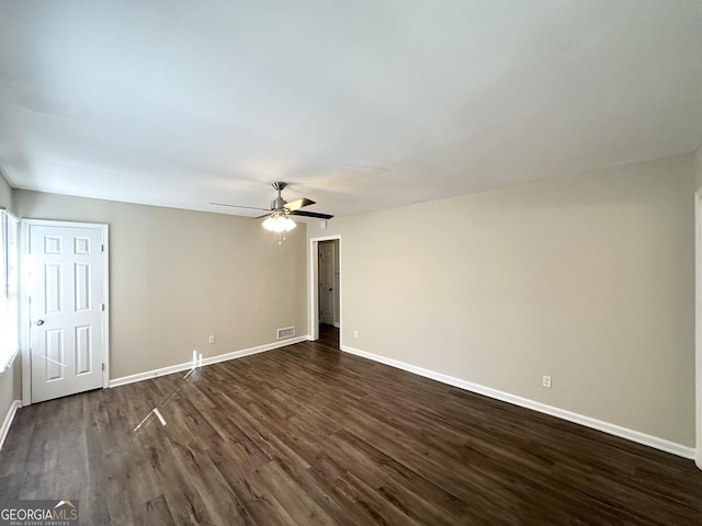 interior space with visible vents, a ceiling fan, baseboards, and dark wood-style flooring